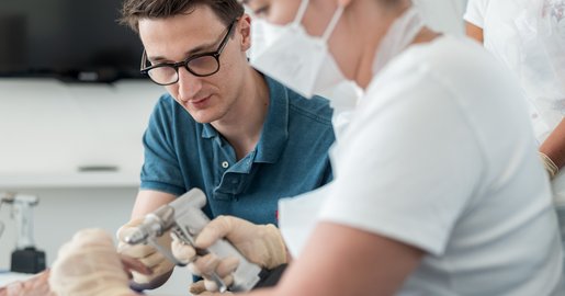 2 Personen beim Operieren einer Hand