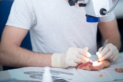 Mann sitzt am Mikroskop